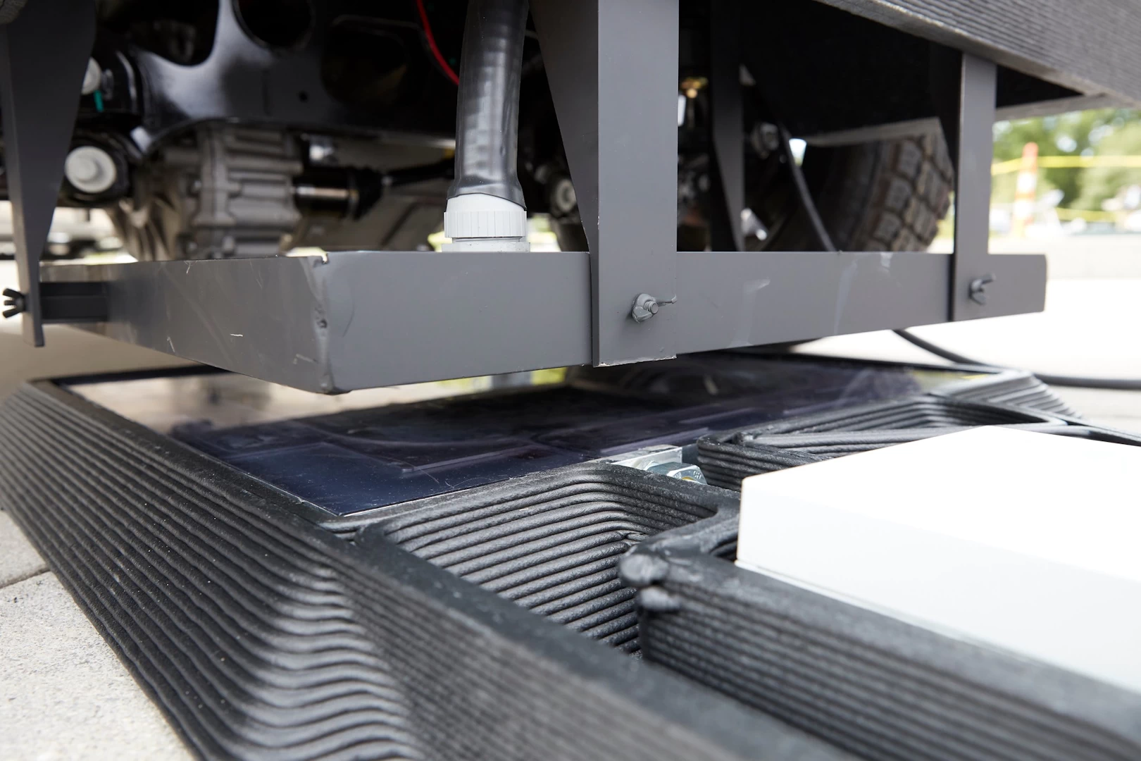 Close up view of a black 3d printed plastic chassis of futuristic jeep during assembly