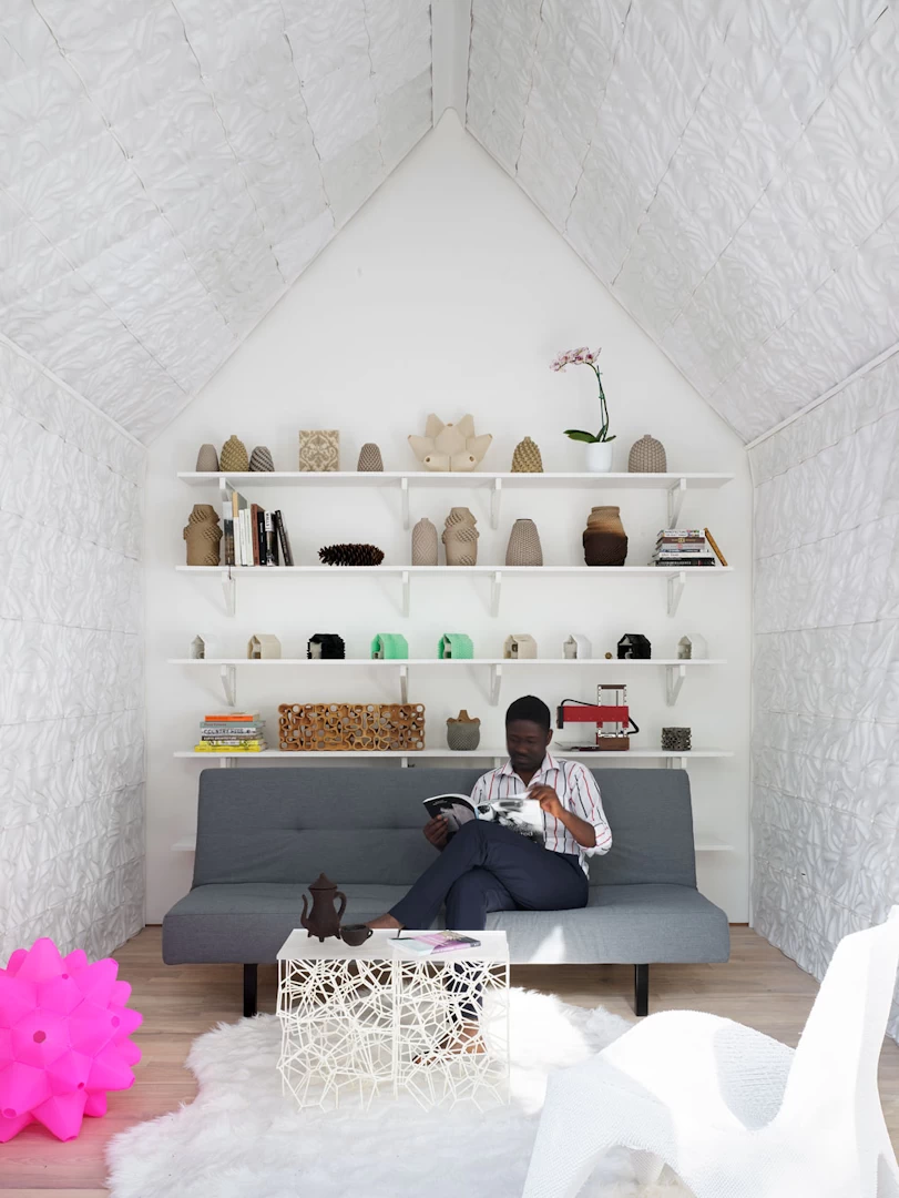 View of lounge inside 3d printed ceramic cottage with white walls and furniture