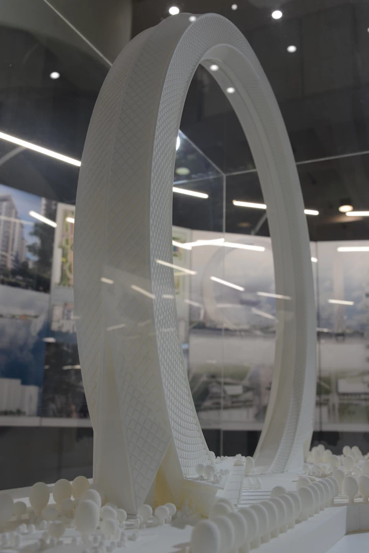 Lower side view of a model of a circular white tower 3d printed in nylon on display