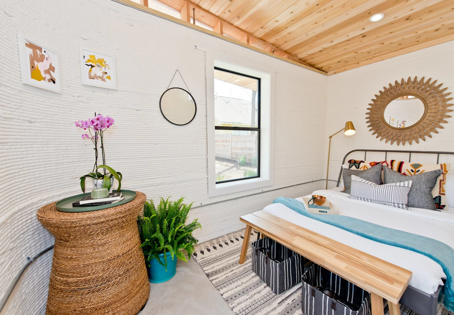 View of furnished bedroom inside 3d printed concrete house with wooden ceiling