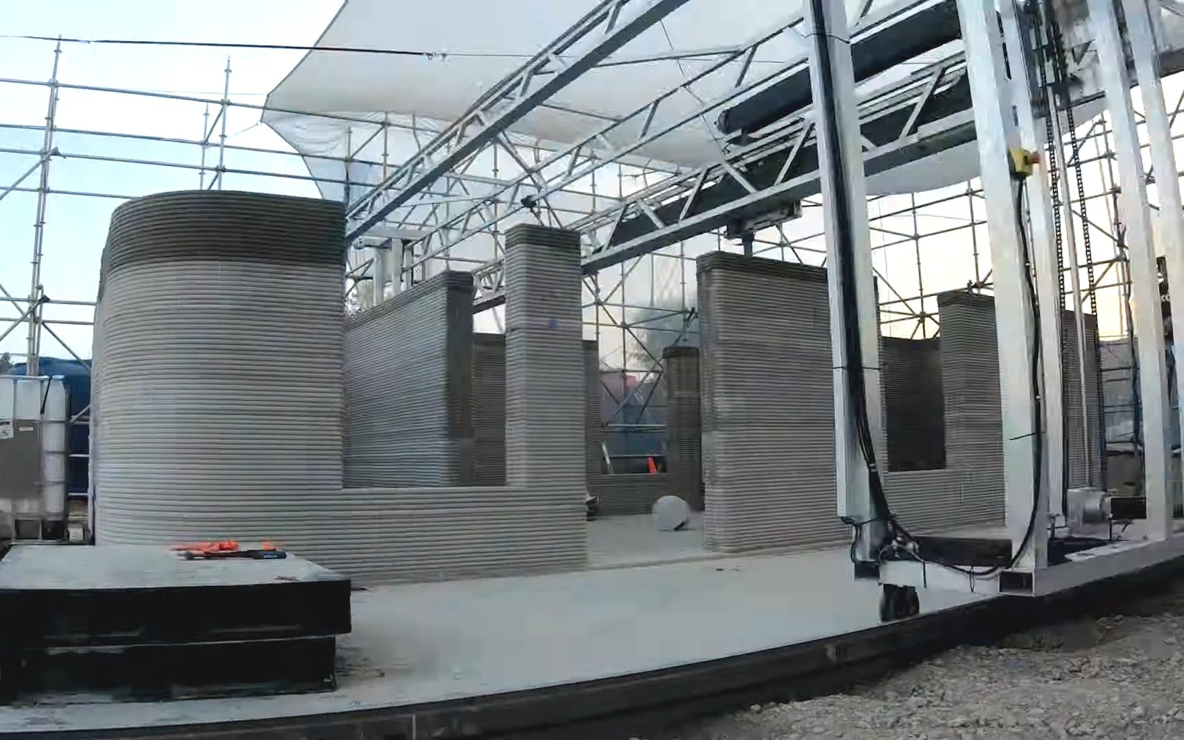 Side view of grey 3d printed concrete house being printed