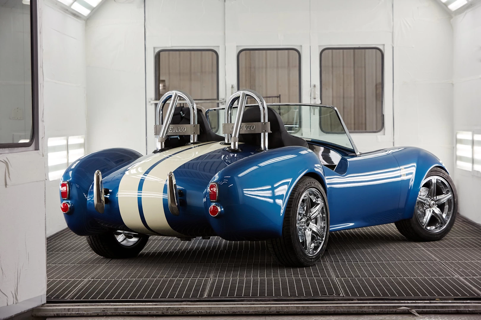 Rear right view of a blue 3d printed plastic cobra car in a spray booth