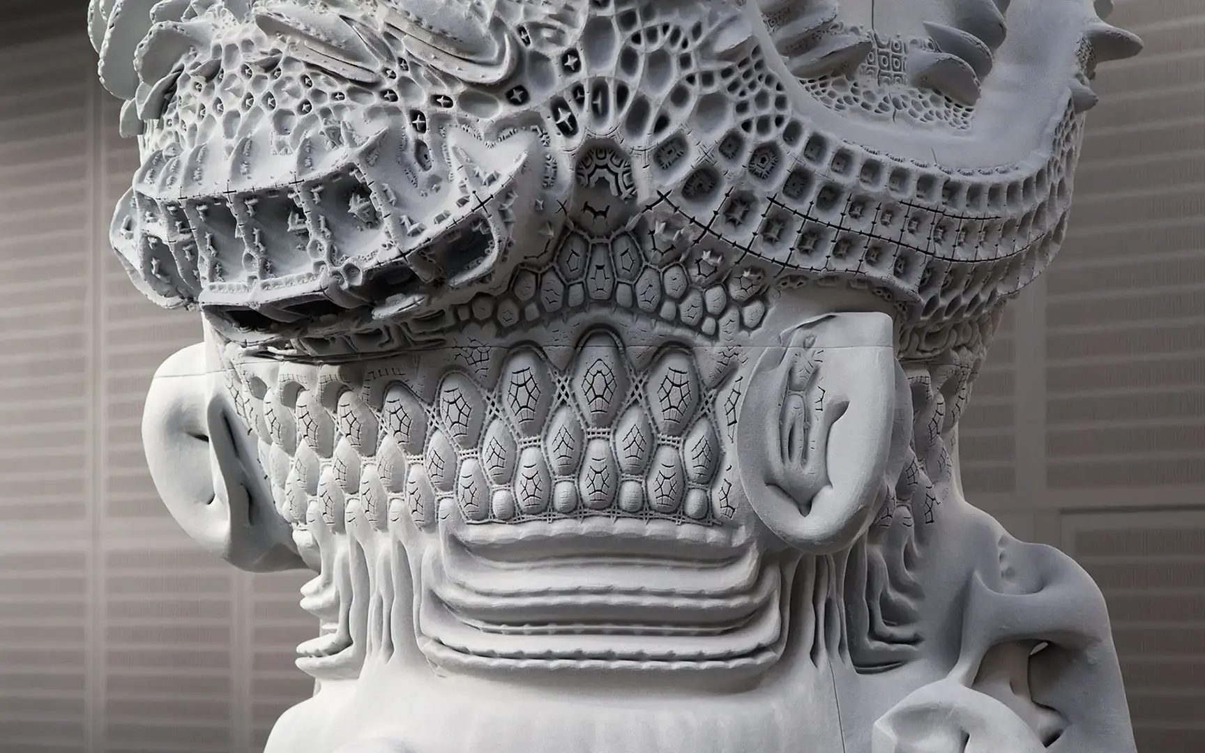 Close up view of the sculpture's complex white surface that has multiple 3D patterns blending into each other
