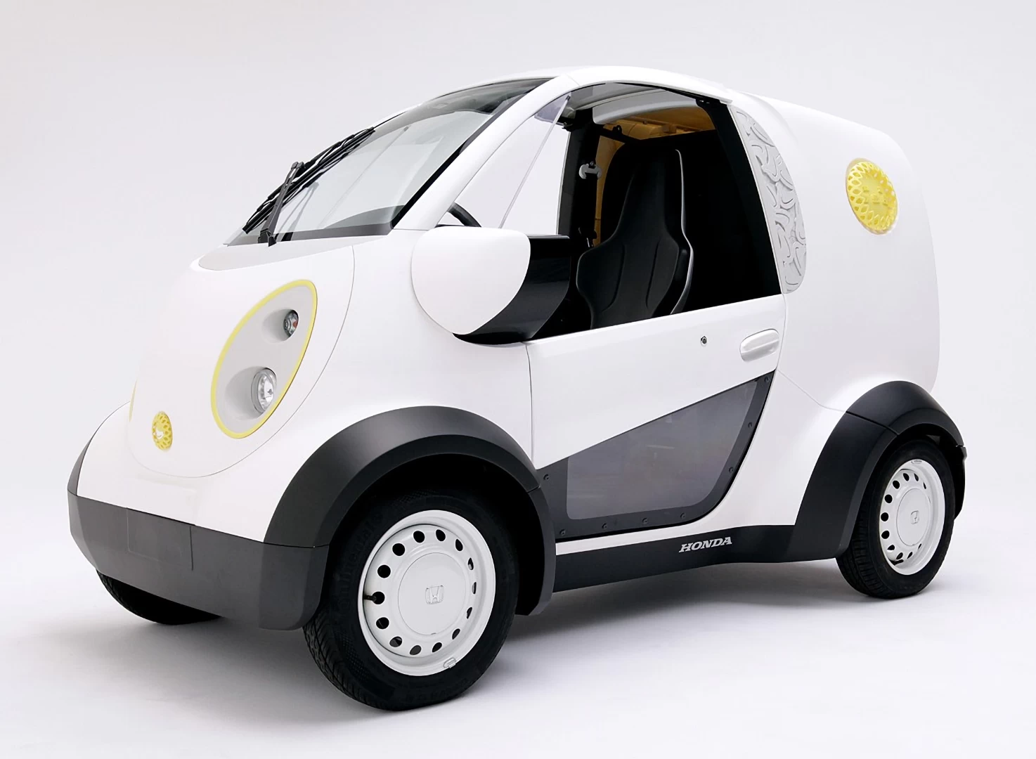 Front left view of a small white 3d printed plastic delivery vehicle