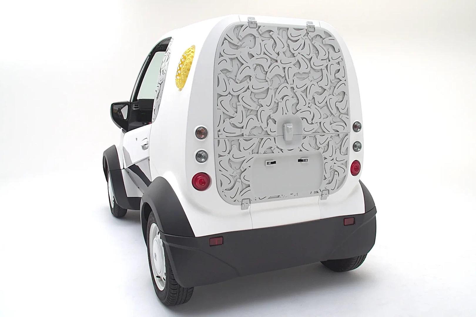 Rear left view of a small white 3d printed plastic delivery vehicle