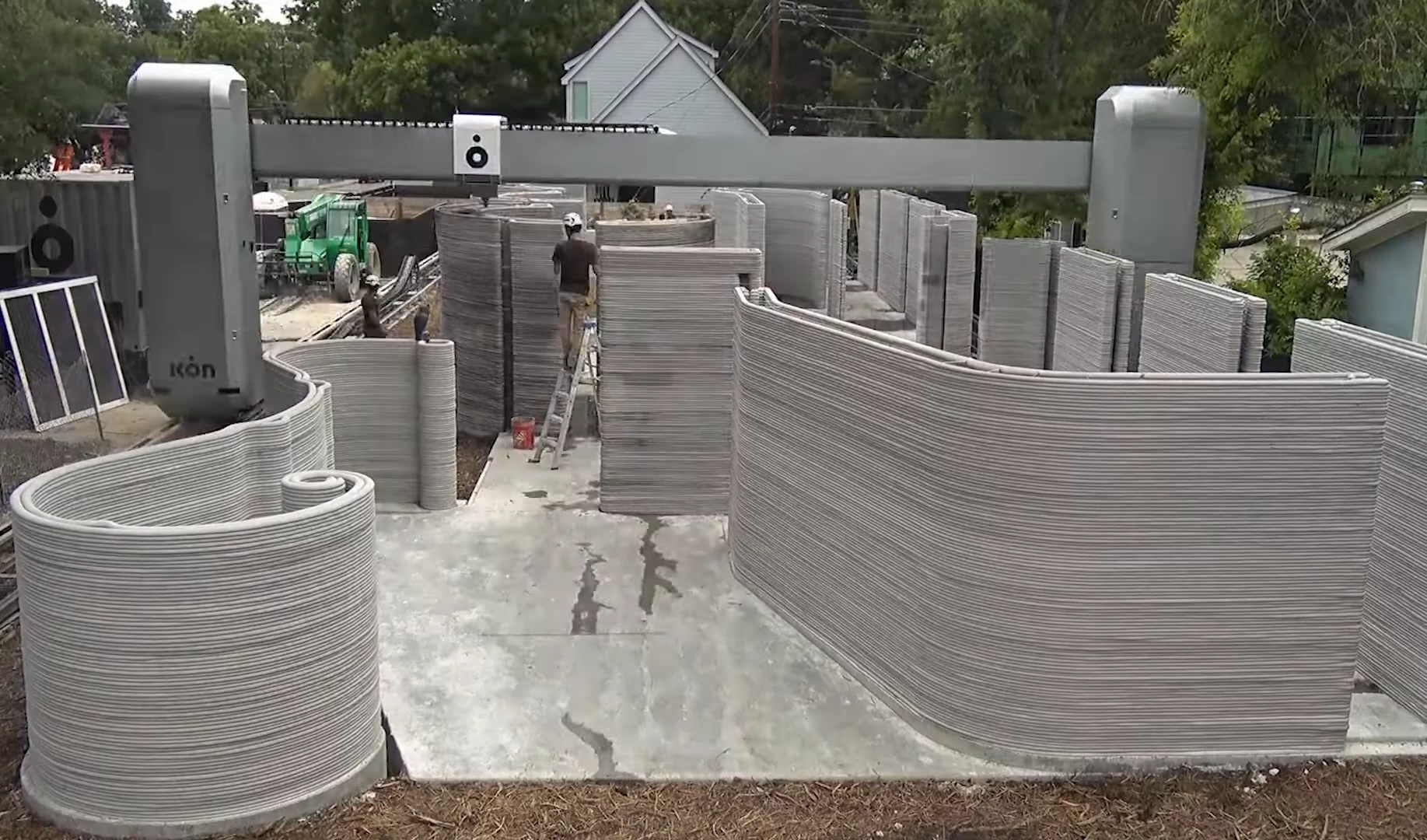 Side view of grey 3d printed concrete house being printed