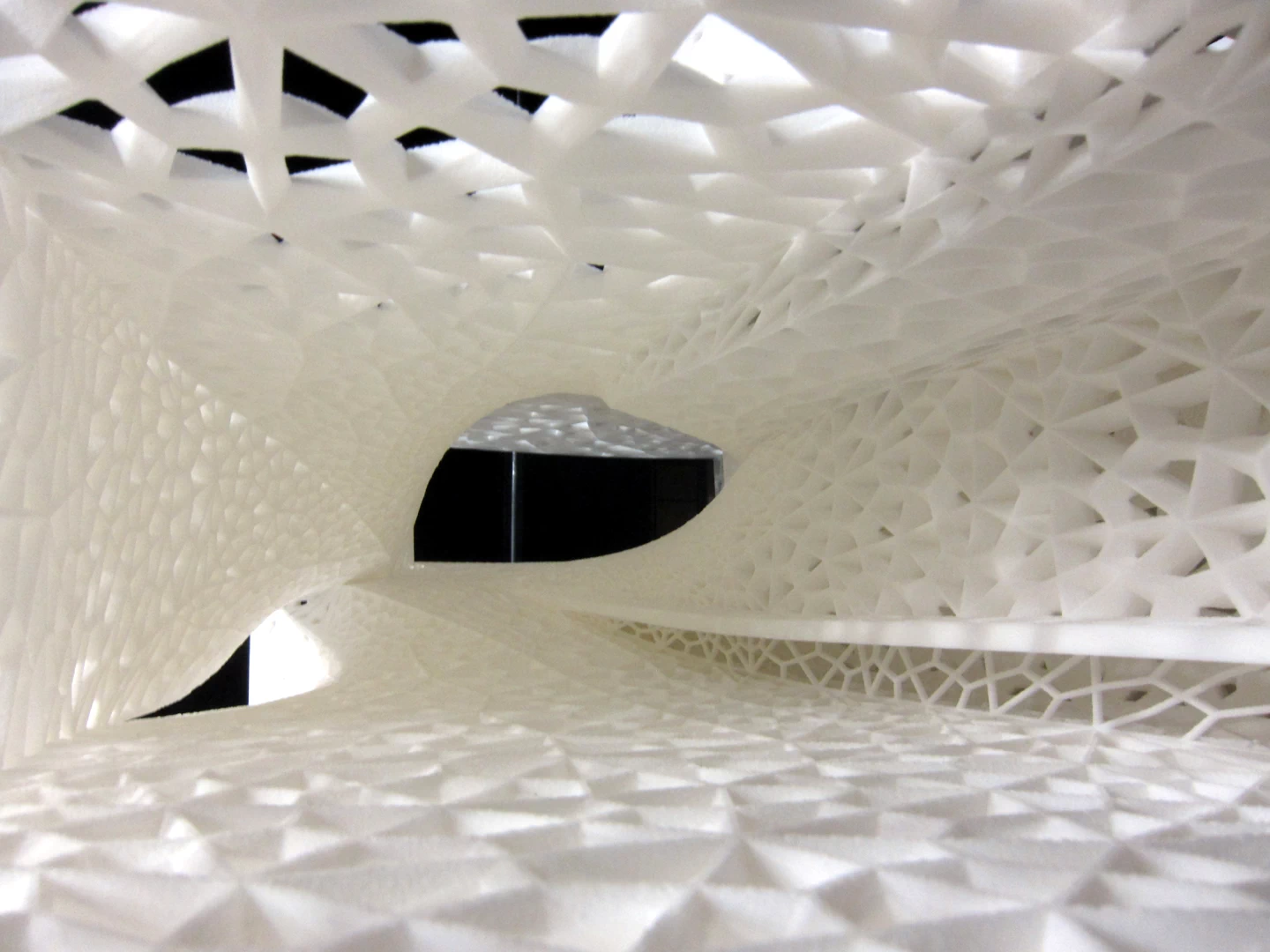 Inside rear view of a white model building shaped with twisted rectangles and patterned walls 3d printed in sintered nylon