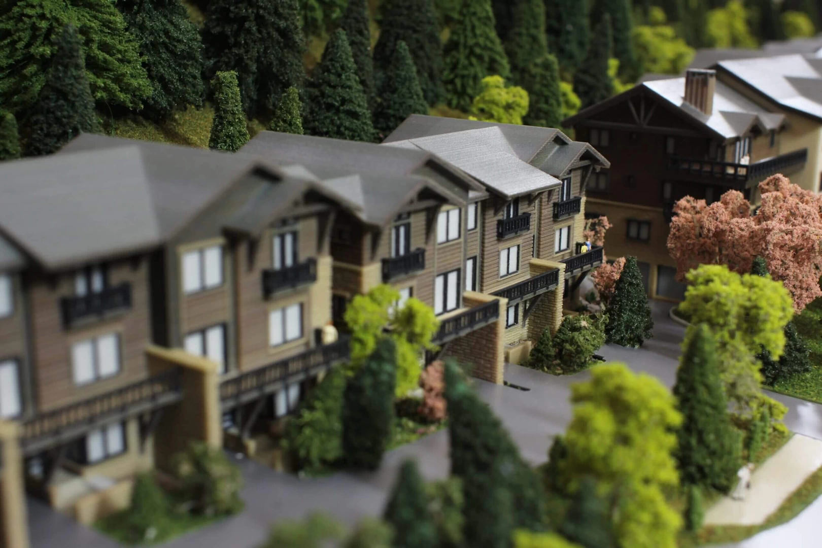 Front side view of a 4 storey wood and stone residential complex in the mountains 3d printed in colour binder jetted powder
