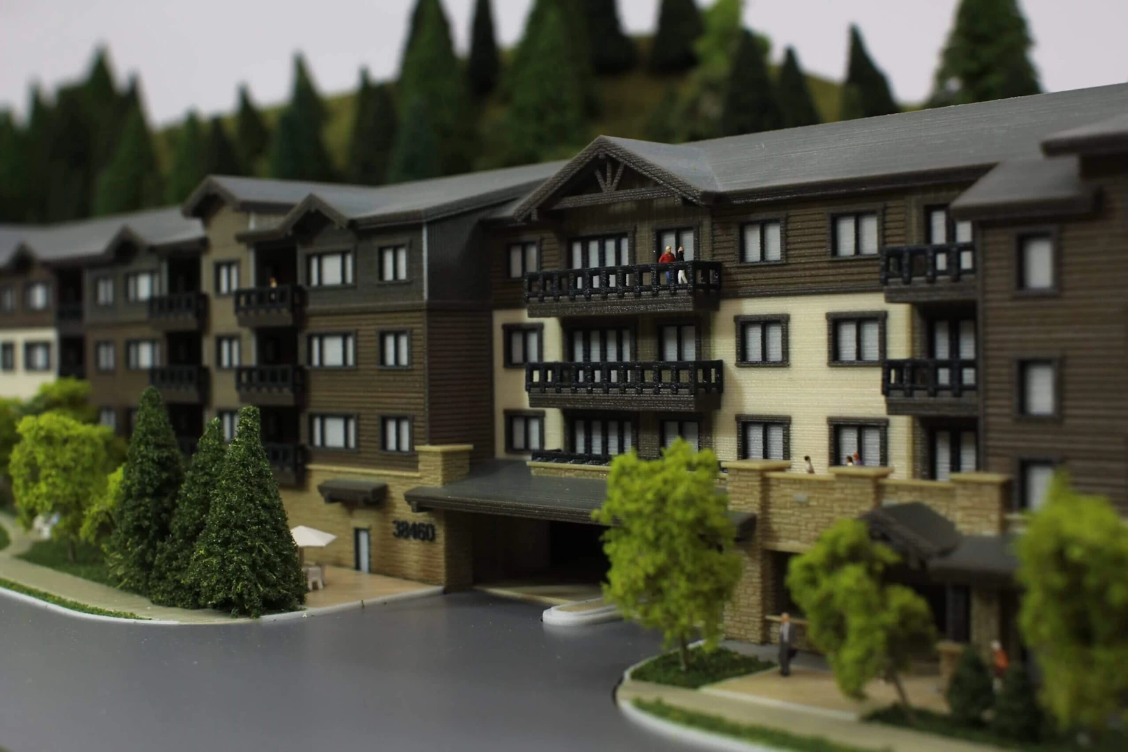 Front view of a 4 storey wood and stone residential complex in the mountains 3d printed in colour binder jetted powder