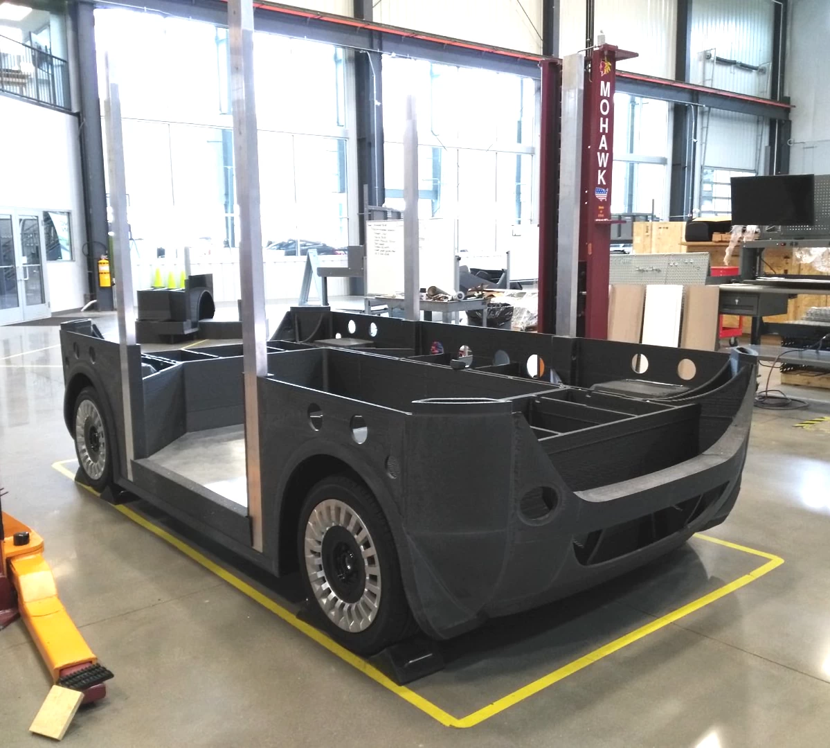 Front right view of a chassis from a grey 3d printed plastic autonomous shuttle during assembly