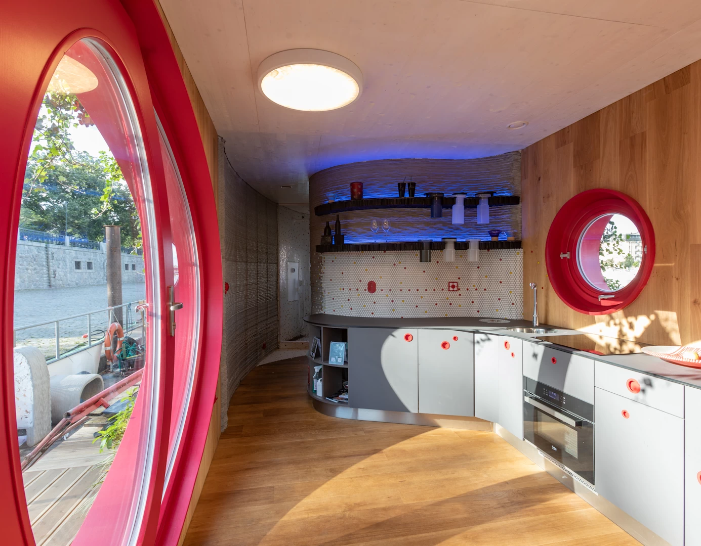 View of entrance and kitchen inside 3d printed concrete cottage with wooden flooring