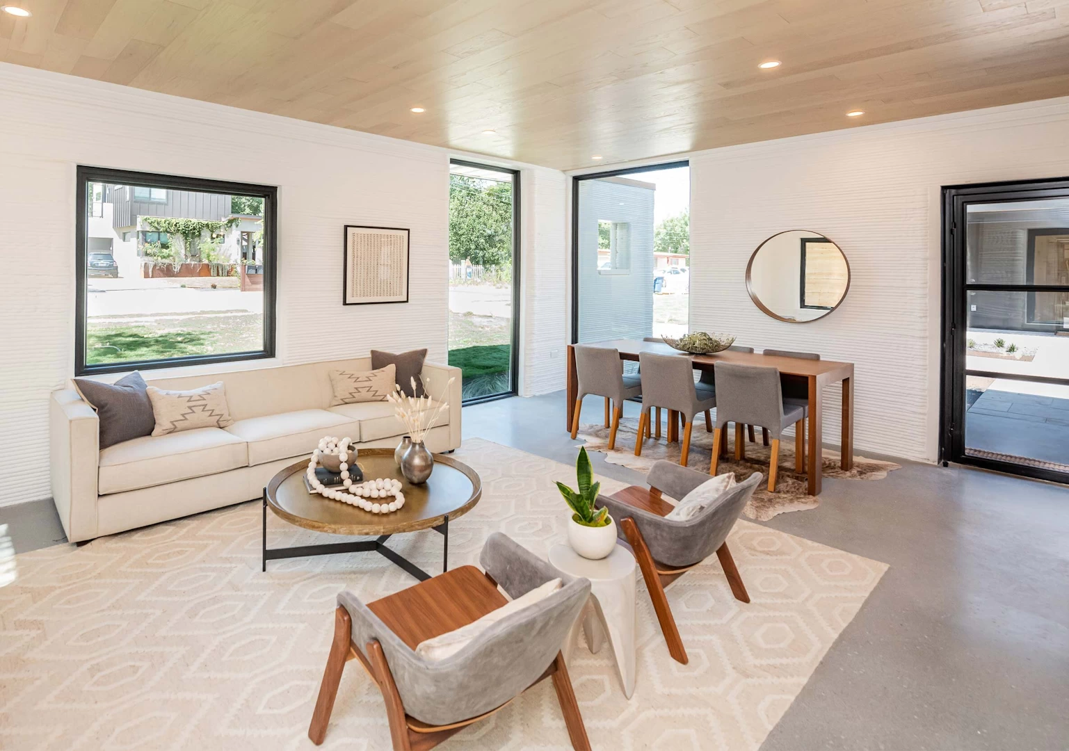 View of furnished lounge inside 3d printed concrete house with wooden ceiling