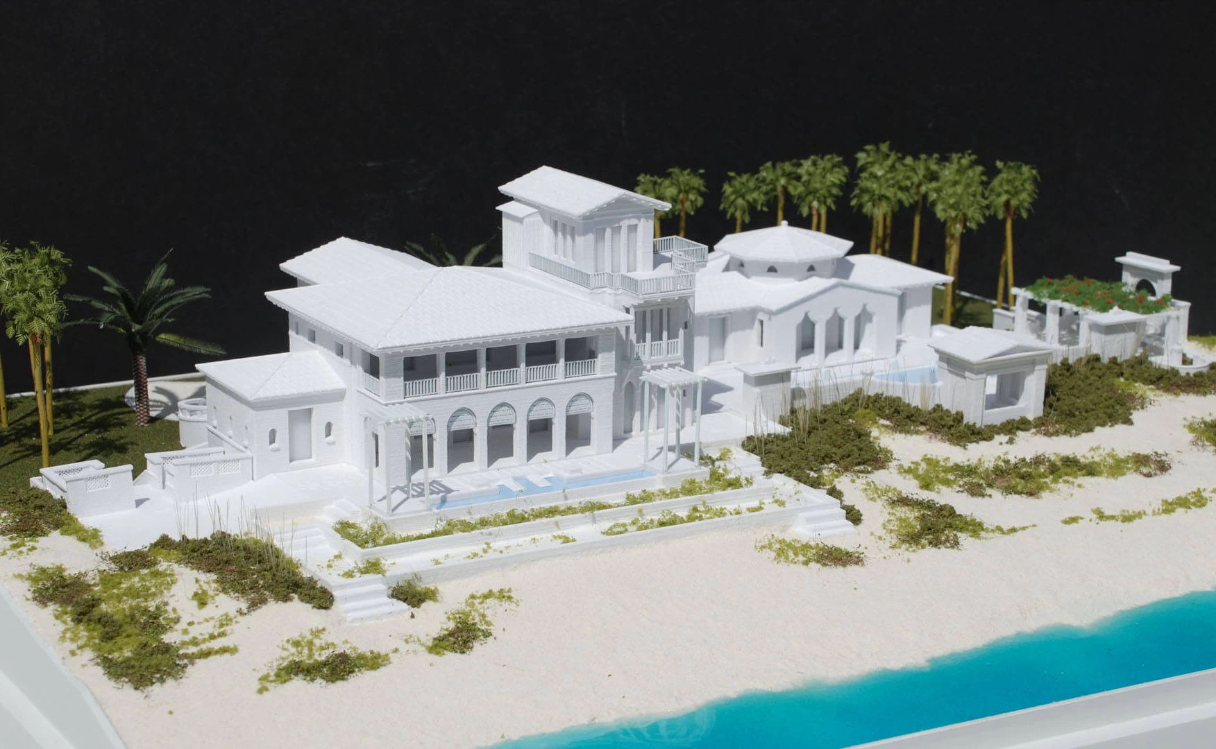 Front view of a 3d printed model of a large white beach house on the coast