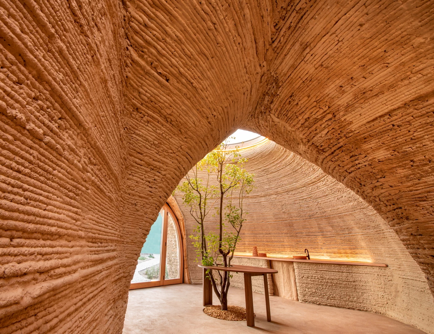 View of living area inside 3d printed clay house with curved walls