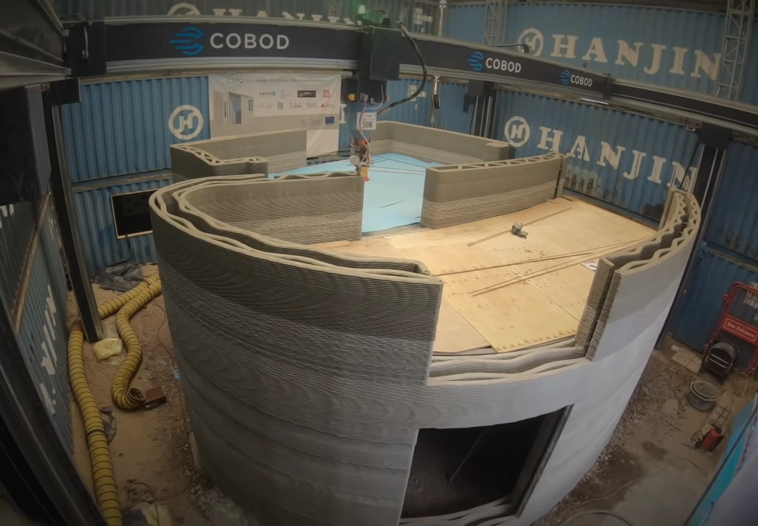 Side view of grey 3d printed concrete house being printed