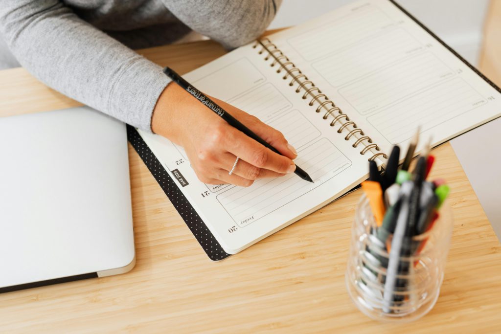 Imagem representando uma pessoa a escrever numa agenda, para ilustrar a ideia da semana laboral de 4 dias