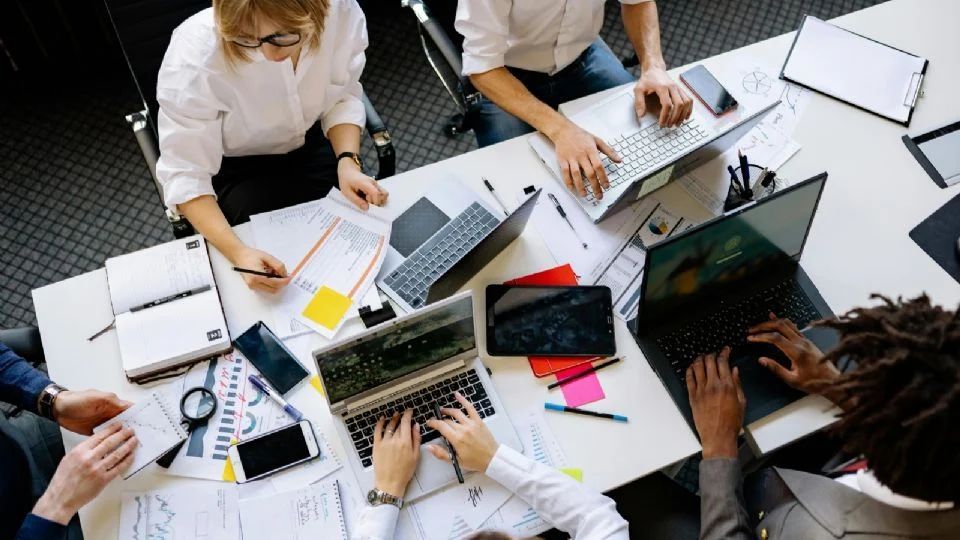 Imagem em picado de cinco pessoas a trabalhar num escritório